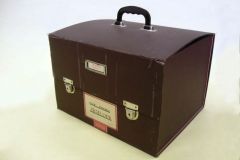 The Big Suitcase, ex. Num. 29;  34 x 29 x 41 cm, date: 2nd half of 20. century, brown cloth on carton, plastic handle, two metal locks and label; District people's committe of city Břeclav, Civil Defence;  Donated by SOkA Břeclav in Mikulov, III/2007